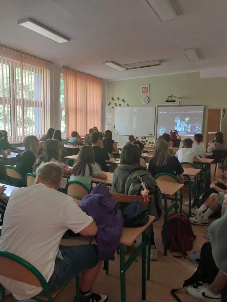 dzieci i pracownicy oglądają na ekranie wylot Sławosza w kosmos