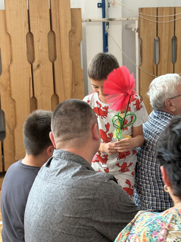 chłopiec wręcza kwiaty własnoręcznie zrobione rodzicom
