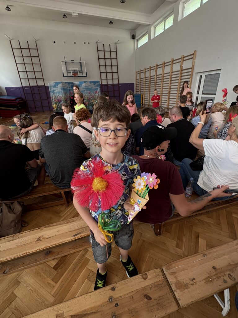 chłopiec wręcza kwiaty własnoręcznie zrobione rodzicom