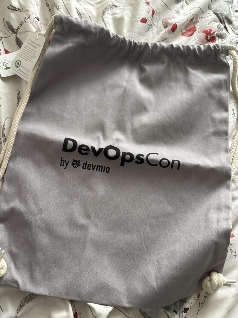 Szary, materiałowy worek z napisem DevOpsCon by devmio.