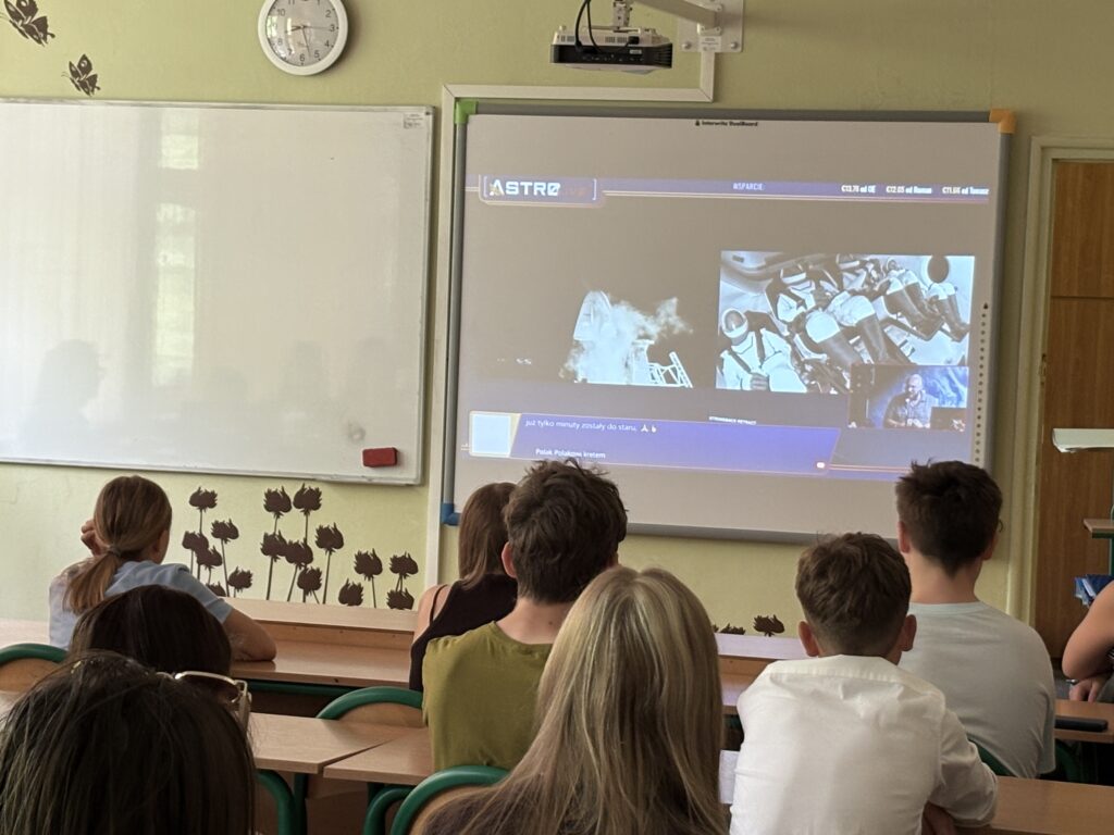 dzieci i pracownicy oglądają na ekranie wylot Sławosza w kosmos