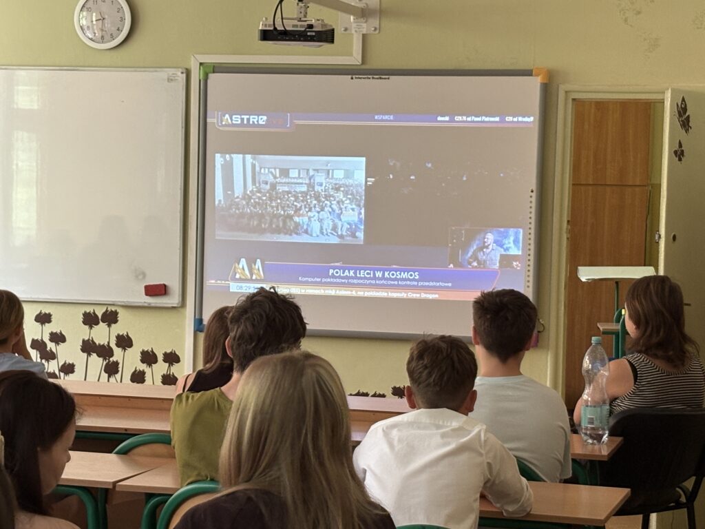 dzieci i pracownicy oglądają na ekranie wylot Sławosza w kosmos