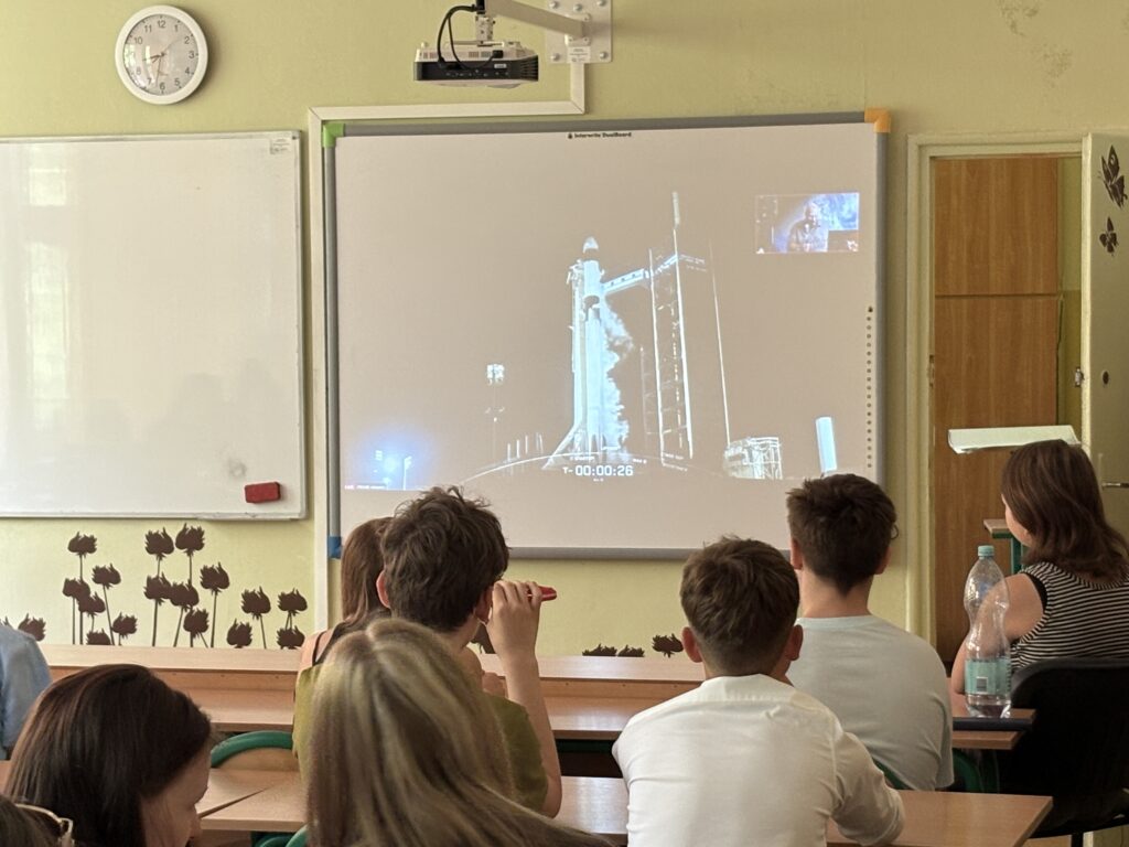 dzieci i pracownicy oglądają na ekranie wylot Sławosza w kosmos