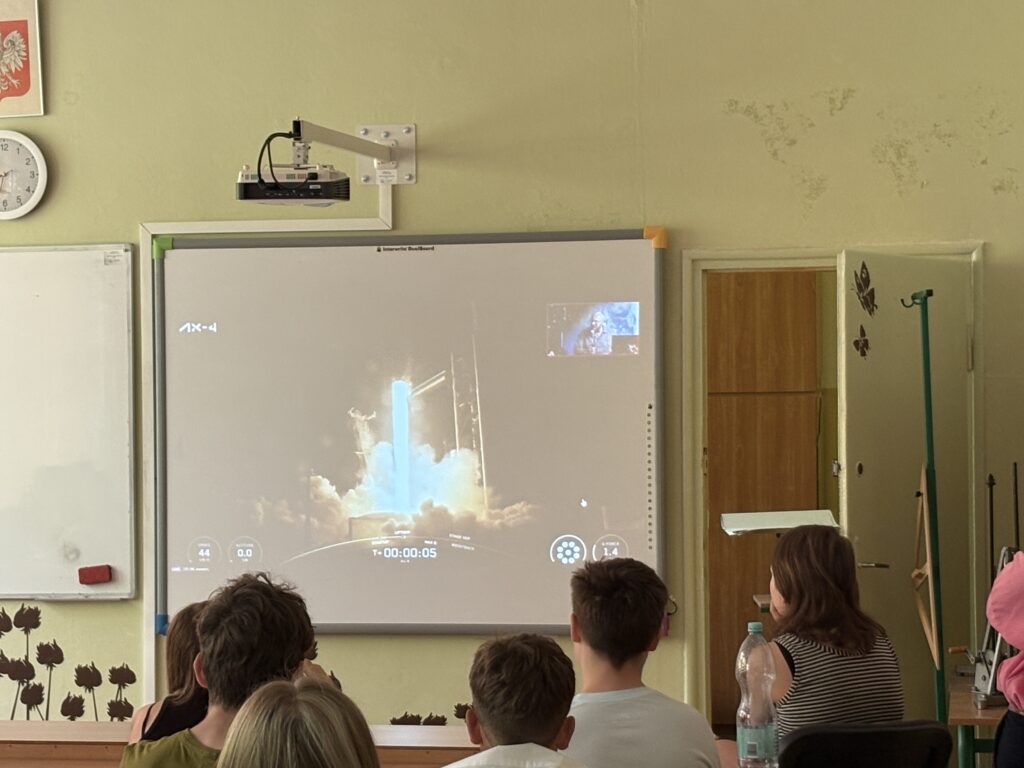 dzieci i pracownicy oglądają na ekranie wylot Sławosza w kosmos