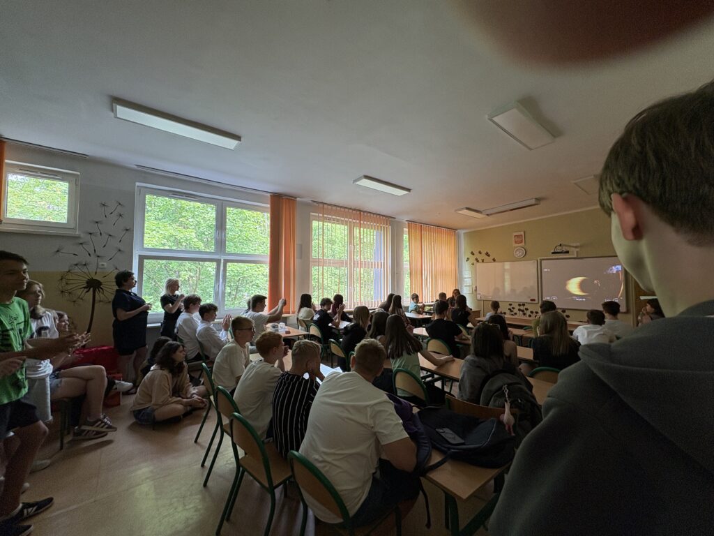 dzieci i pracownicy oglądają na ekranie wylot Sławosza w kosmos