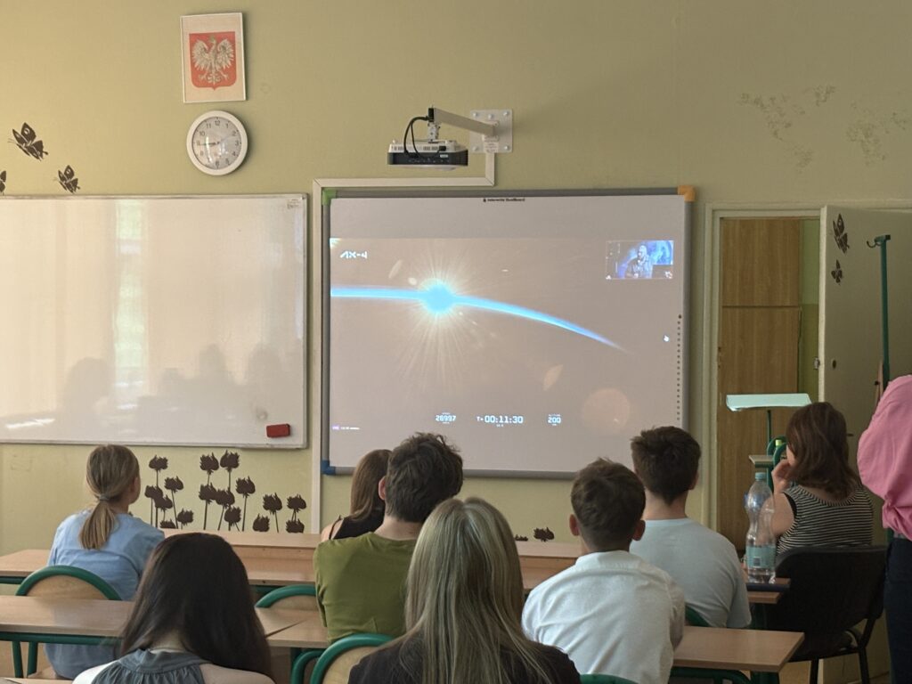 dzieci i pracownicy oglądają na ekranie wylot Sławosza w kosmos