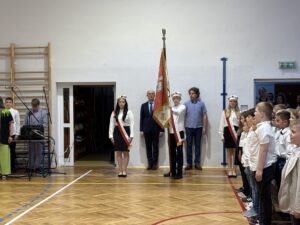 poczet sztandarowy, obok nauczyciel i pracownik szkoły