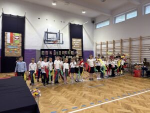 uczniowie podczas udziału w przedstawieniu. Klasy 1-2. Machają kolorowymi chustami.