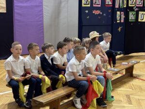 uczniowie siedzący na ławce podczas występu