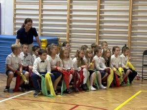 uczniowie siedzący na ławce podczas występu