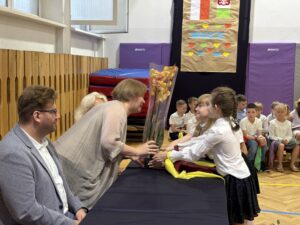 uczniowie wręczają kwiaty storczyki- dyrektorom.