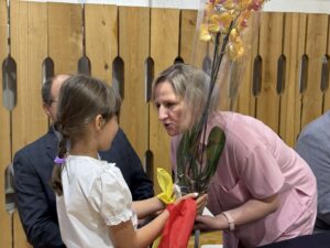 uczniowie wręczają kwiaty storczyki- dyrektorom.