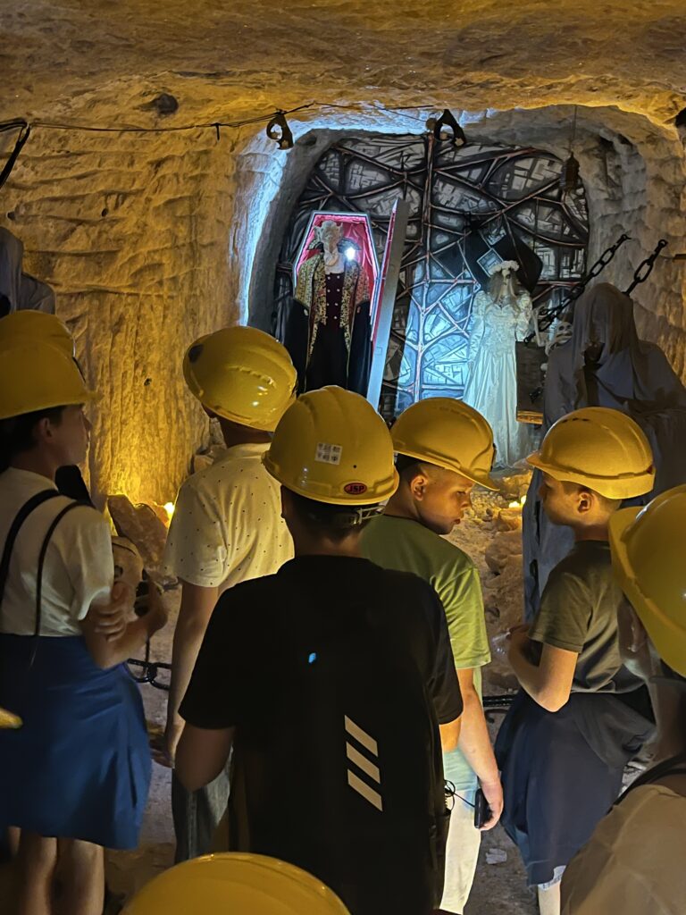 Fotografia przedstawia zdjęcie uczniów znajdujących się w kopalni soli.