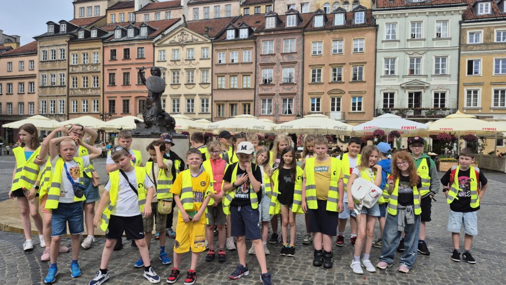 zdjęcie grupowe uczniów w żółtych kamizelkach, na Starym Mieście