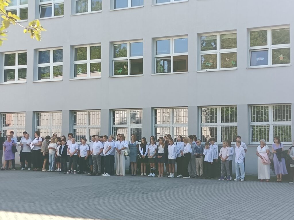 zdjęcie grupy uczniów i nauczycieli na apelu szkolnym przed szkołą