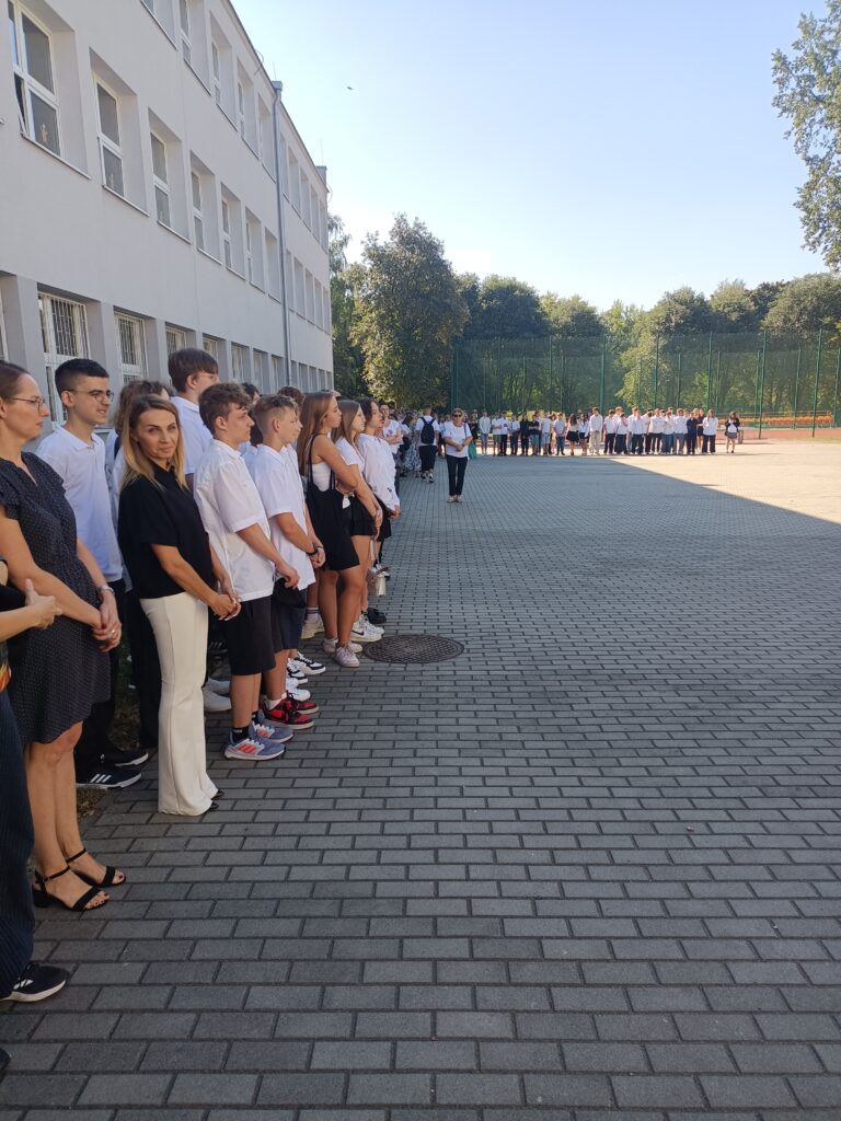 zdjęcie grupy uczniów i nauczycieli na apelu szkolnym przed szkołą
