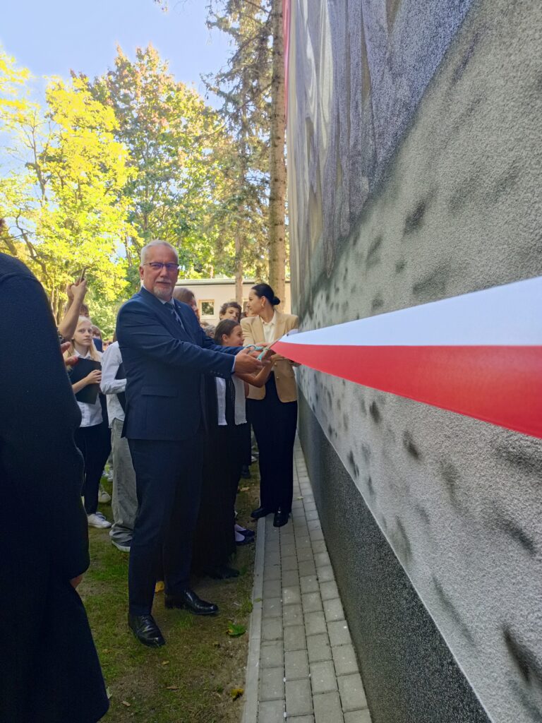 mężczyzna przecina wstęgę