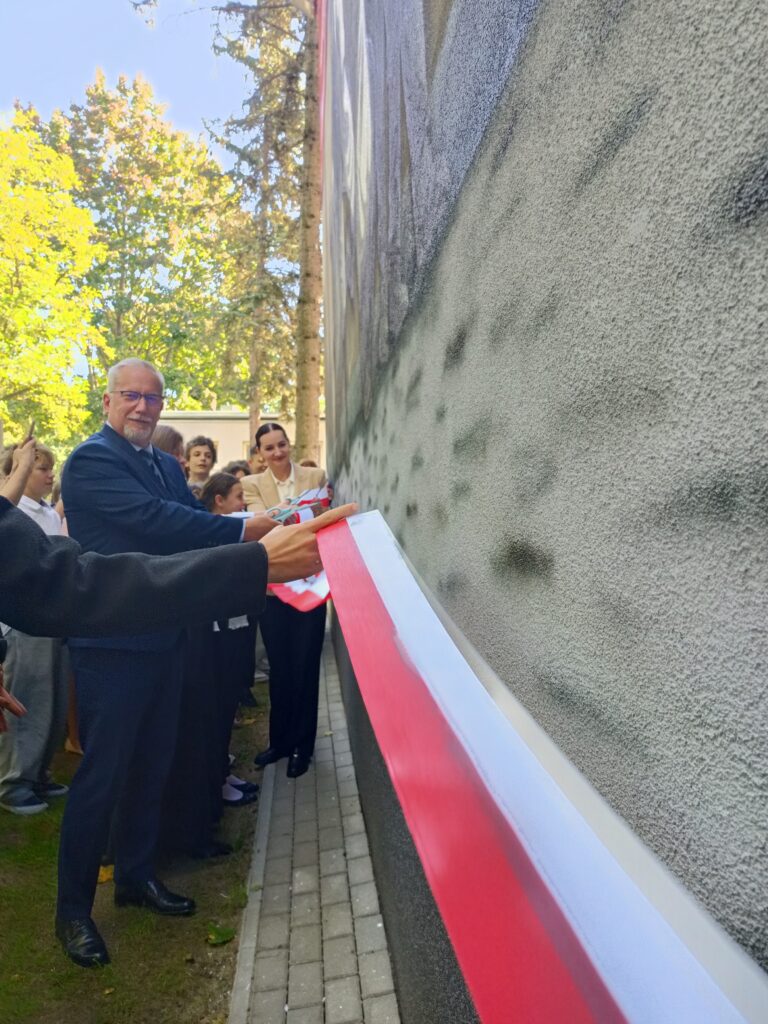 mężczyzna przecina wstęgę