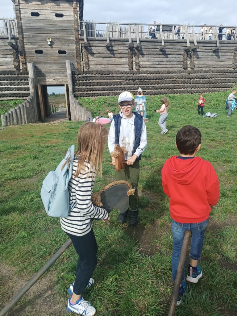 dzieci bawią się "konikami na patyku"
