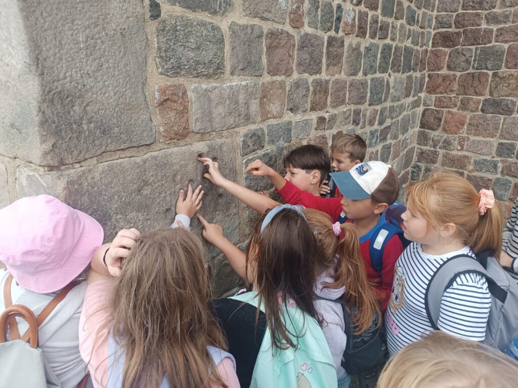 dzieci wkładają palce w dziury w zamku