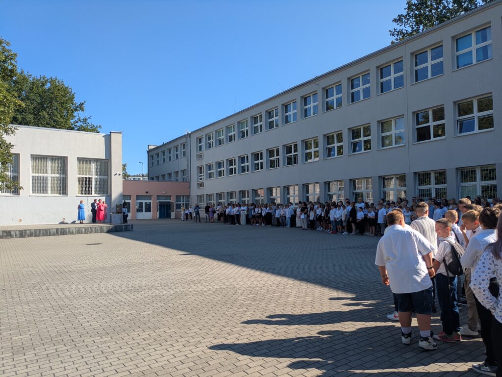 zdjęcie grupy uczniów i nauczycieli na apelu szkolnym przed szkołą