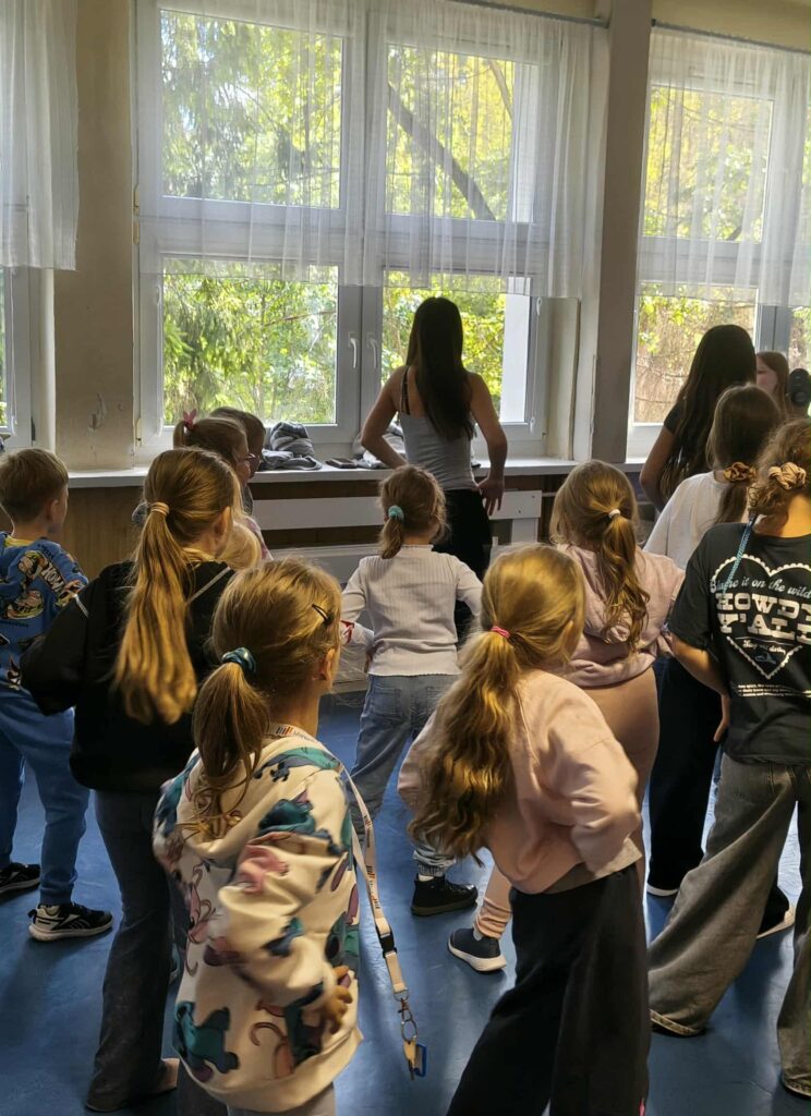 dzieci tańczą na korytarzu w szkole