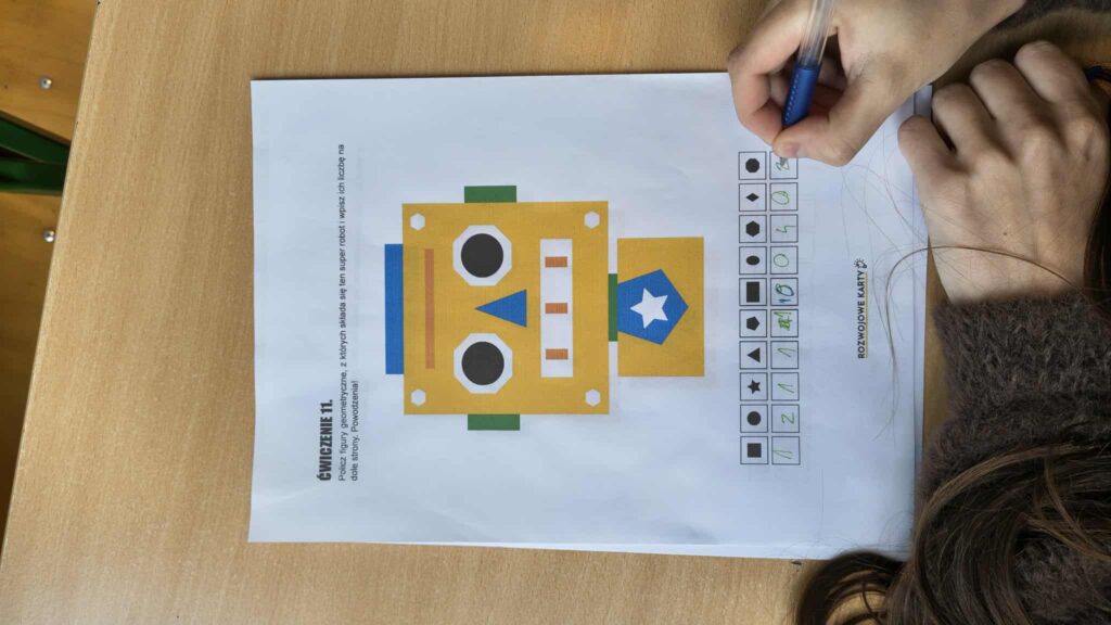 widać rączki jak rozwiązują zadanie na kartce 