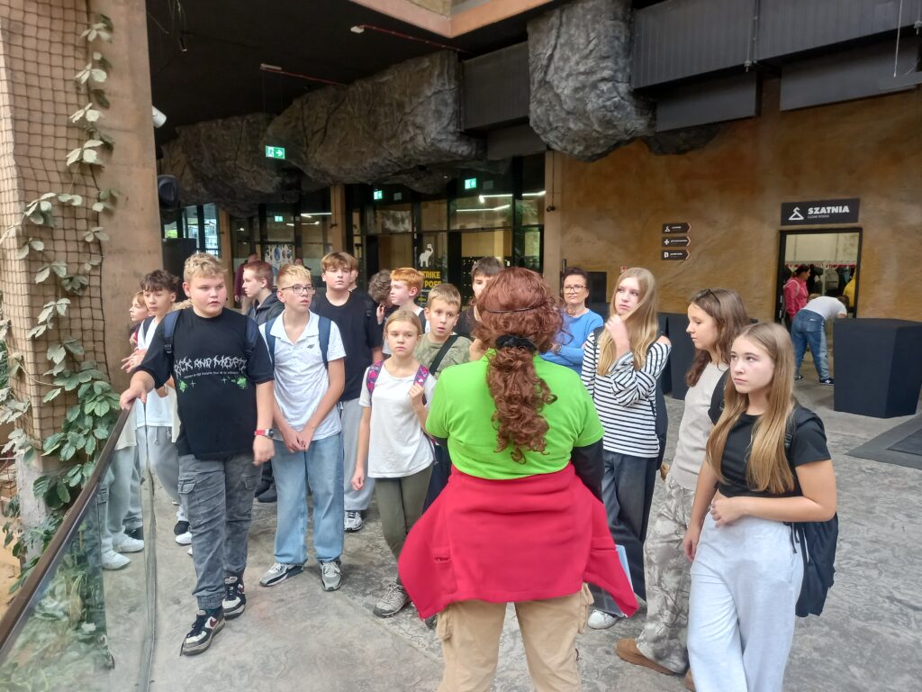 dzieci słuchają przewodnika stojąc