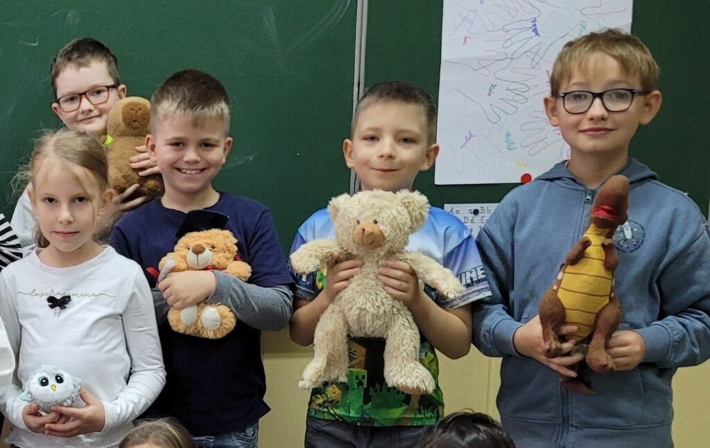 dzieci uśmiechnięte trzymają misie w rękach