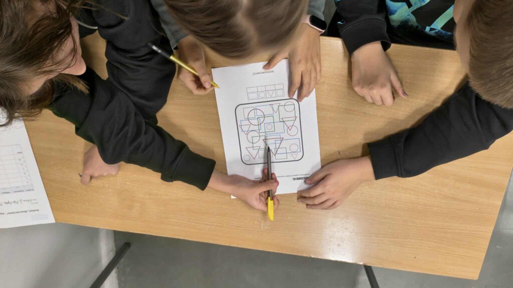 widać rączki jak rozwiązują zadanie na kartce 