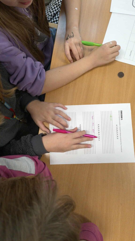 widać rączki jak rozwiązują zadanie na kartce 