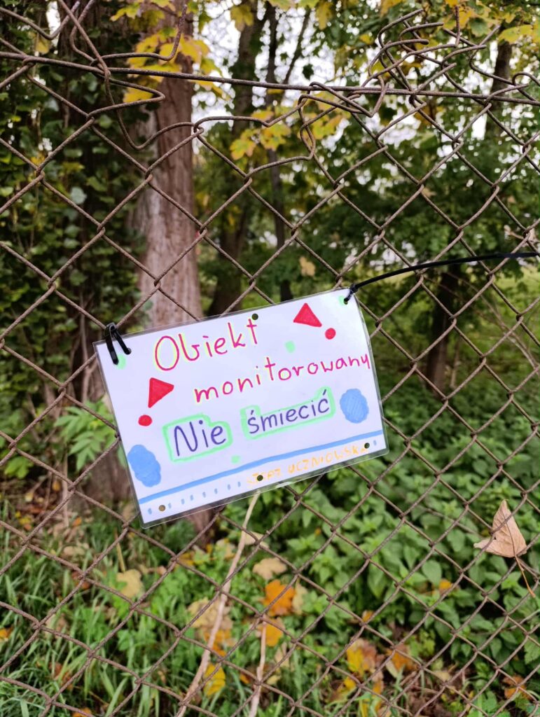 naklejona na płocie kartka z napisem obiekt monitorowany nie śmieć