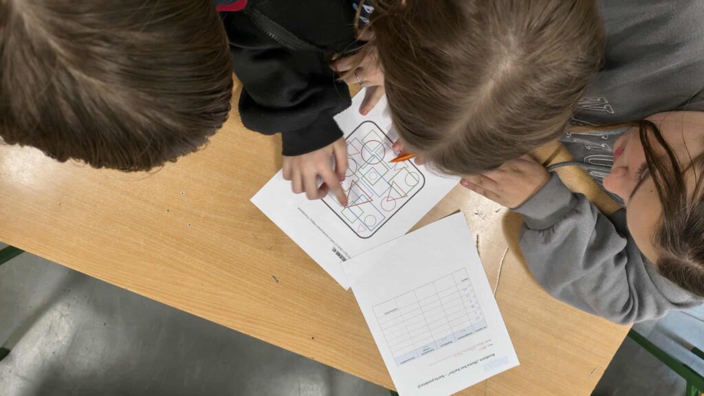 widać rączki jak rozwiązują zadanie na kartce 