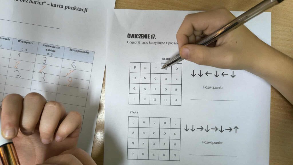 widać rączki jak rozwiązują zadanie na kartce 