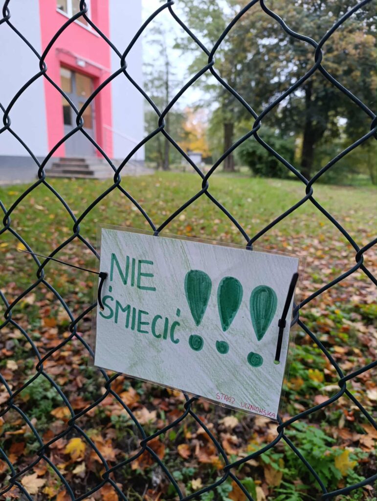 naklejona na płocie kartka z napisem nieśmieć