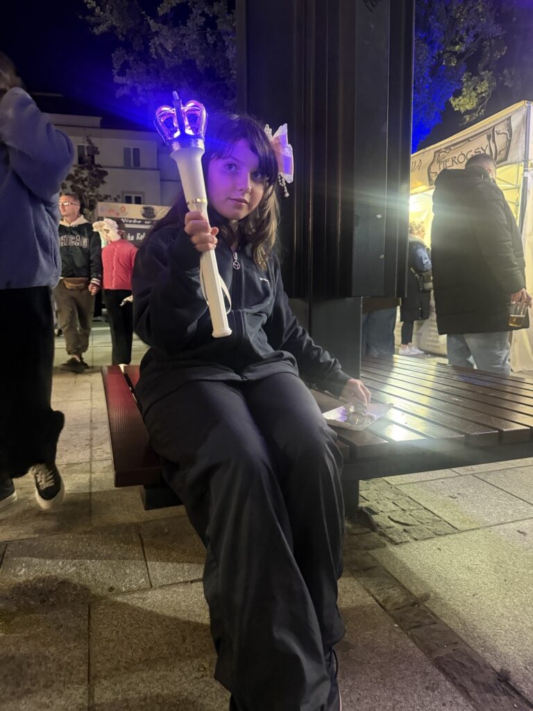 Tosia z 6 a - dziewczynka siedzi na ławce, w ręku trzyma podświetlony lampion