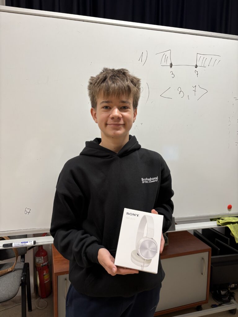 uczeń trzyma słuchawki - nagrodę.