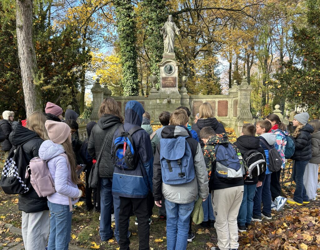 dzieci stoją tyłem do aparatu i patrzą na mauzoleum Grohmanów