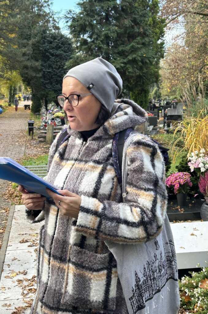 nauczycielka czyta z książki historię cmentarza