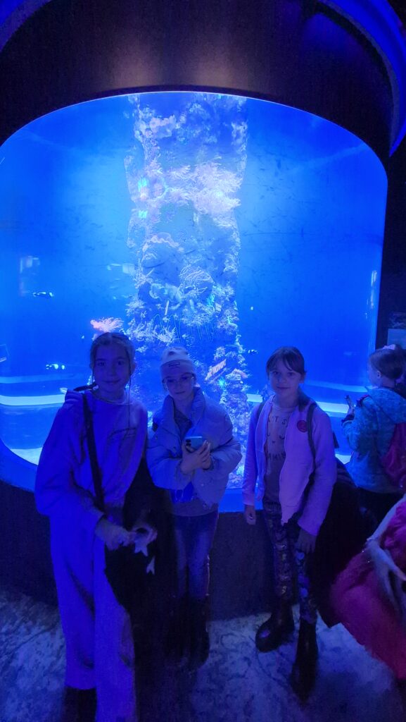 dziewczynki pozujące przed akwarium