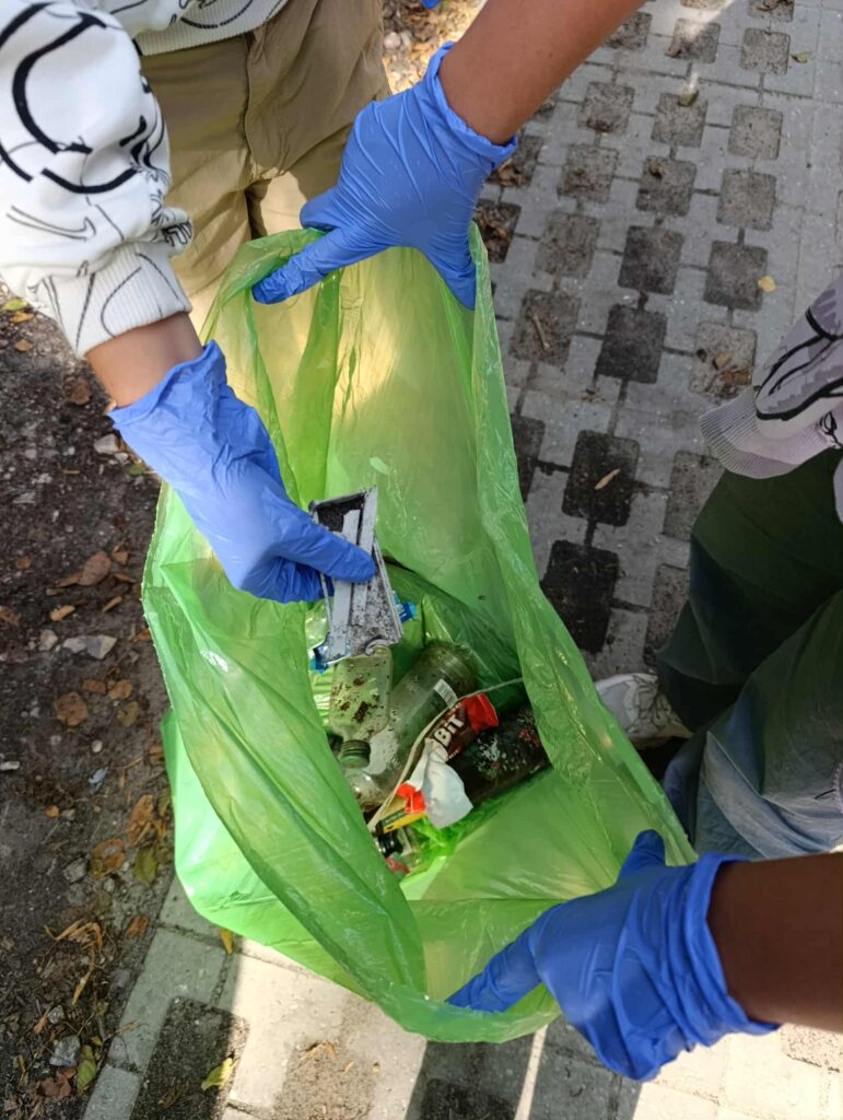 dzieci sprzątają śmieci do worka
