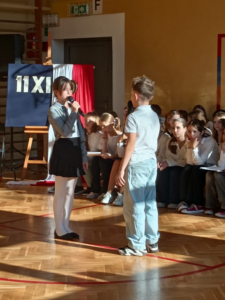 uczniowie z mikrofonami podczas apelu