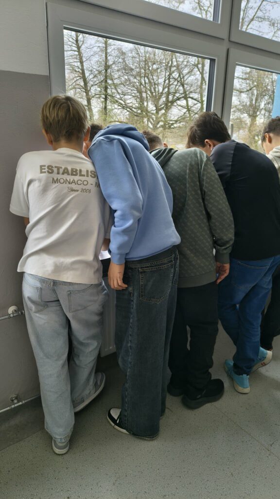 widzimy dzieci które  wykonują karty pracy na parapetach 