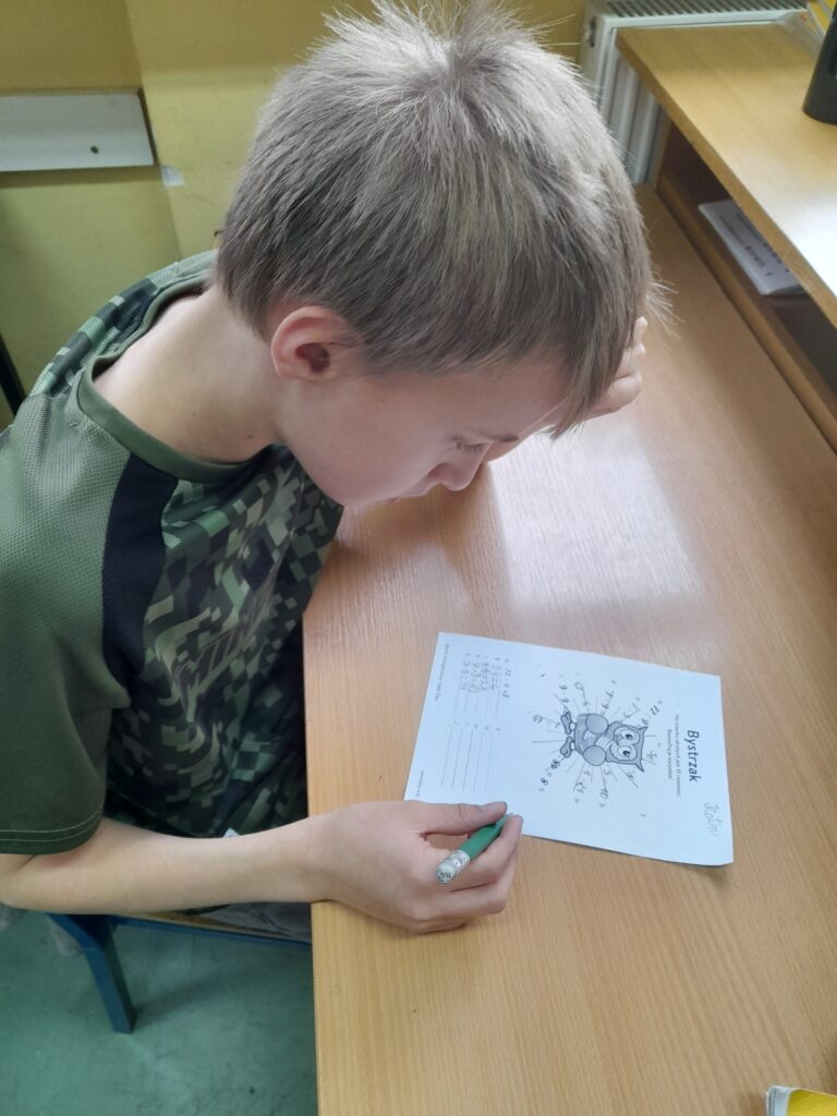 uczeń rozwiązuje zadania z tabliczką mnożenia 