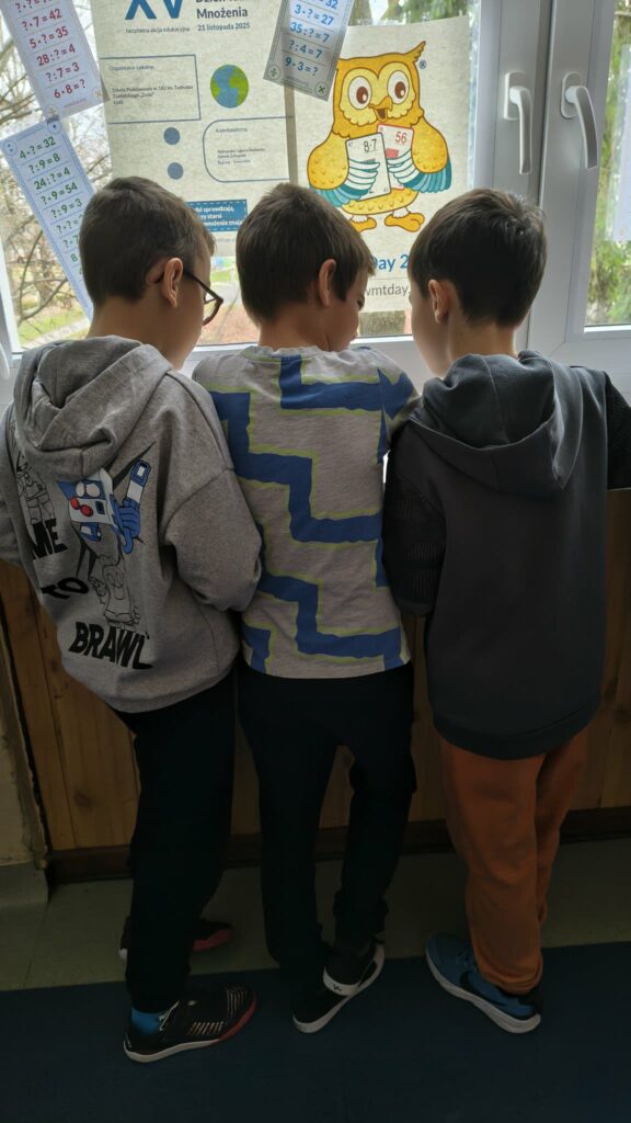 widzimy dzieci które  wykonują karty pracy na parapetach 