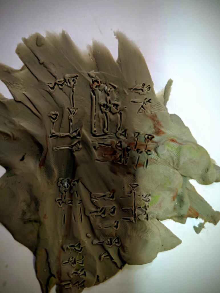 zdjęcie przedstawia wycięcia w plastelinie jakieś znaki