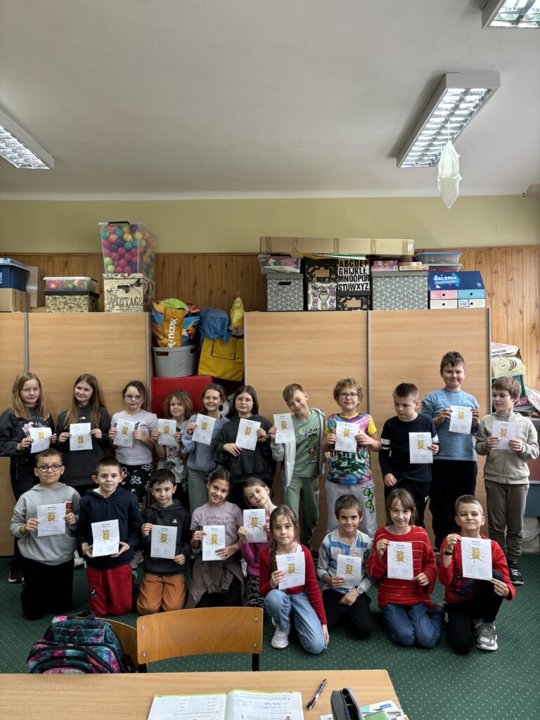 zdjęcie jednej z klas, dzieci prezentują wykonane przez siebie zadania związane z tabliczką mnożenia