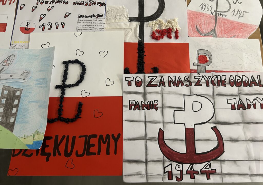 zdjęcie plakatów w kolorach biało czerwonych, na nich widnieją: znak Polski Walczącej, rok 1944, słowa pamiętamy, dziękujemy