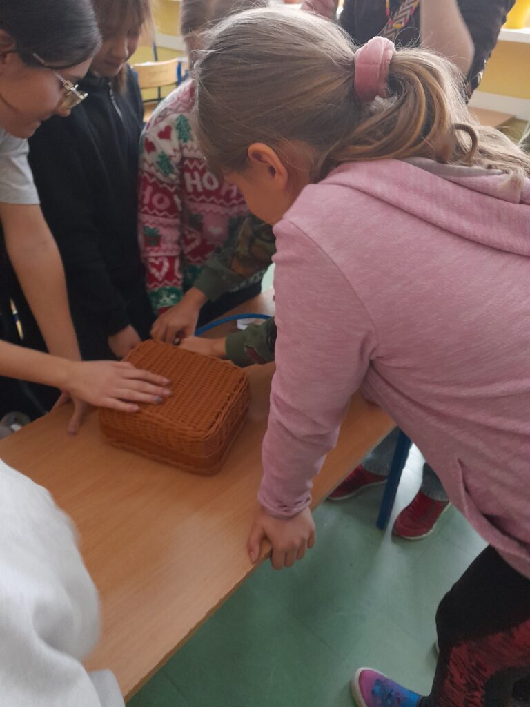 uczniowie bawią się kuferkiem