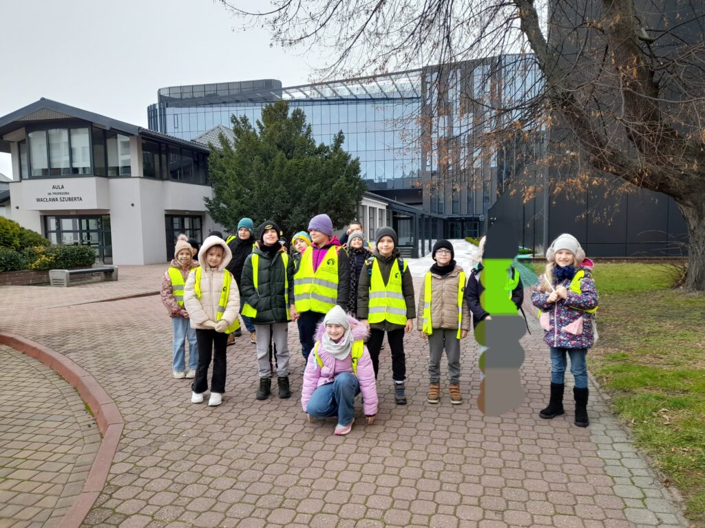 uczniowie stoją w żółtych kamizelkach na terenie Uniwersytetu Łódzkiego 